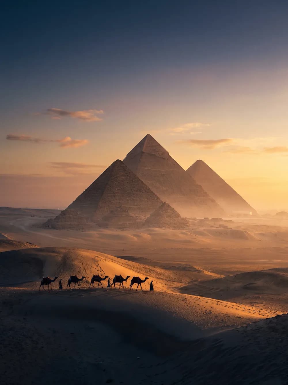 أهرامات الجيزة تتوهّج في ضوء المساء الدافئ فوق القاهرة